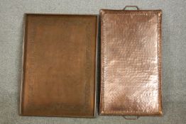 Two planished copper trays, one with two handles, the other with a chased floral border. L.64 W.