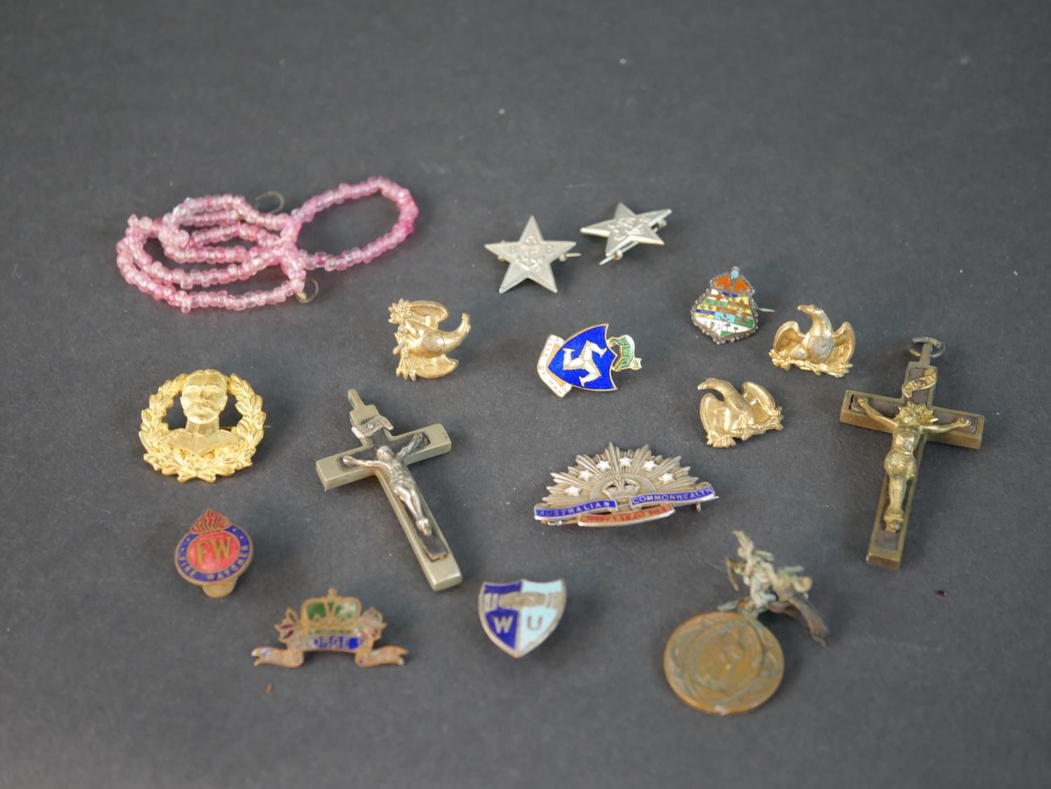 A collection of military badges, pins and crucifixes, including an Australian Commonwealth