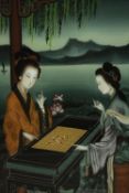 A 20th century Chinese reverse painted glass picture of two ladies playing Go on a terrace in