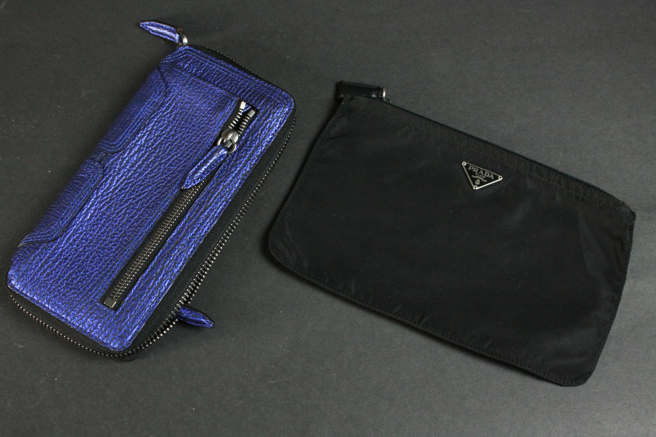 A vintage black silk Prada zip purse along with a Philip Lim metallic blue leather clutch bag. H.
