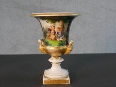 A 19th century hand painted porcelain Classical style urn with figural form handles. One side