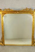 A Victorian giltwood framed overmantel mirror of rectangular form, the bevelled mirrored plate
