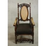 An early 20th century carved oak Charles II style armchair, the top rail carved with a crown over an