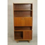 A circa 1970s teak bureau bookcase, with two shelves over a fall front enclosing pigeonholes,