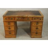 A late Victorian pine pedestal desk, with a brown leathert insert over an arrangement of nine