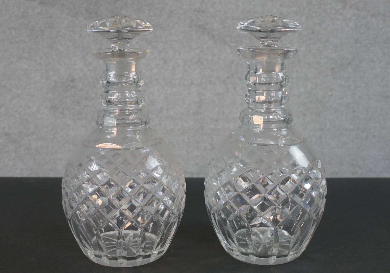 A pair of cut crystal decanters with star cut bases and mushroom stoppers. H.25cm