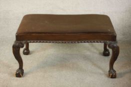 A George II style Victorian walnut stool, upholstered in brown fabric, with a gadrooned edge, on