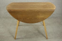 A blonde elm Ercol drop leaf dining table. Maker's label to underside. H.71 W.123cm. (extended)