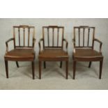 A set of three Sheraton style mahogany open armchairs, upholstered with brown leather seats, studded