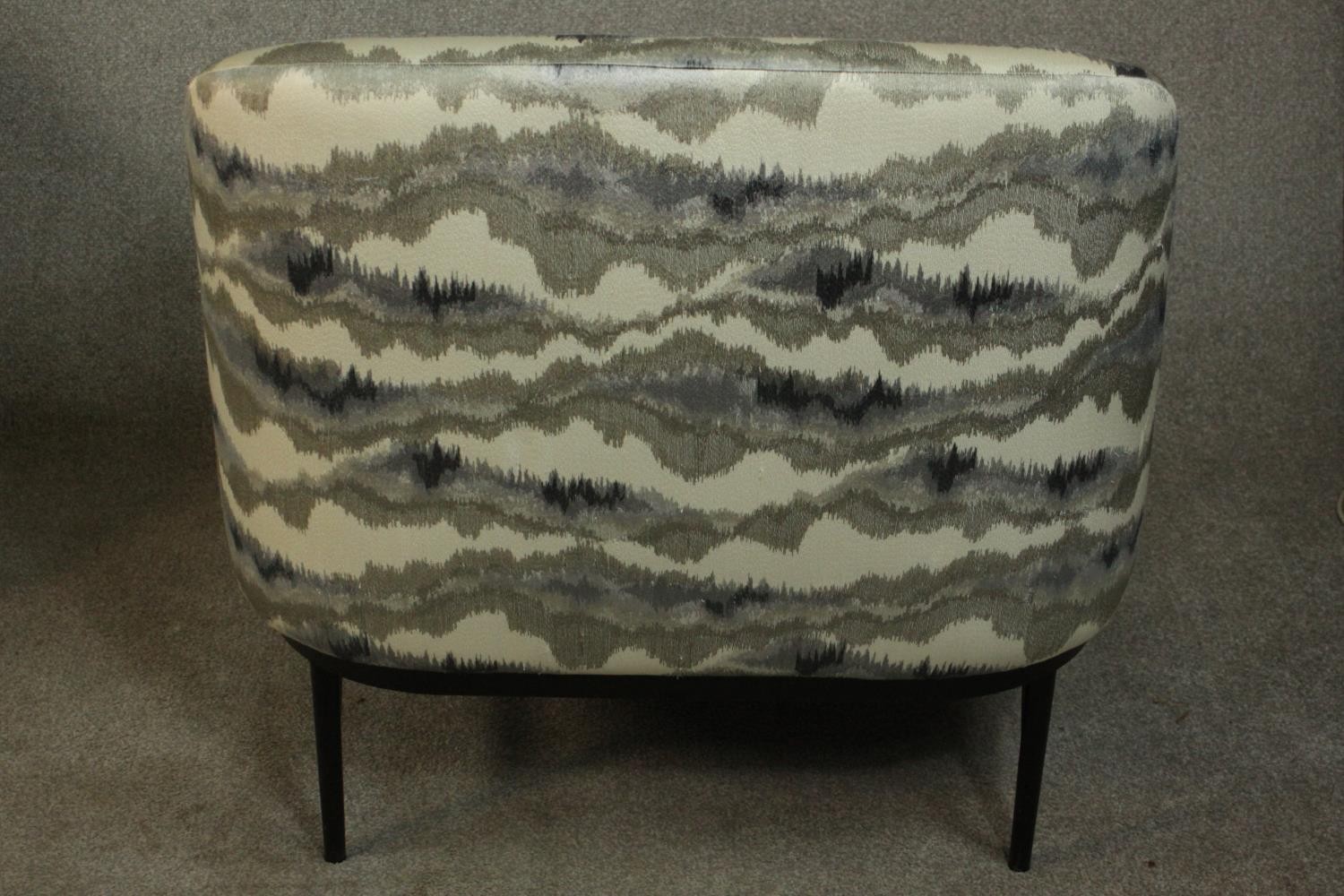 A pair of retro styled armchairs, with patterned upholstery in hues of grey, on a black powder - Image 7 of 13