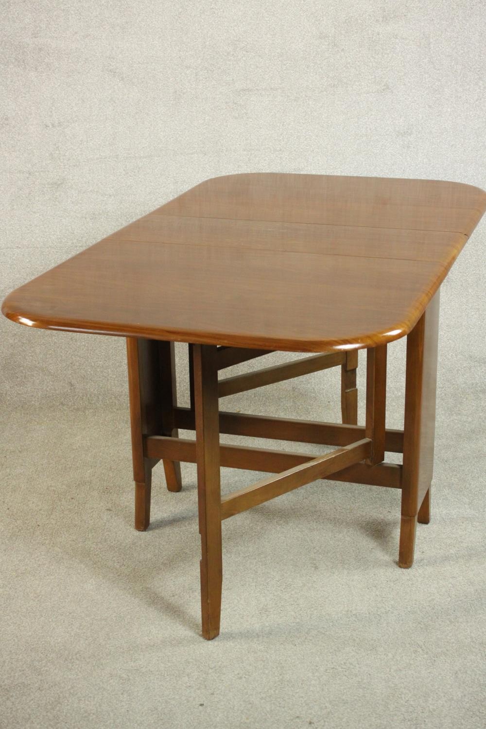 A mid 20th century walnut drop leaf dining table, the two leaves with rounded corners on a base with - Image 4 of 9