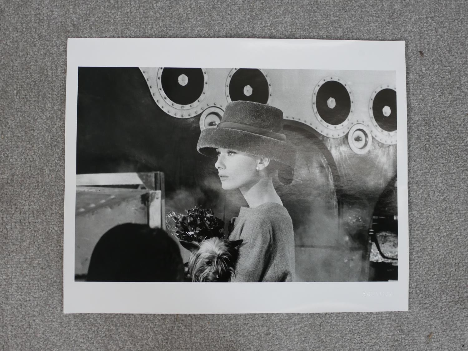 A black and white photo of Audrey Hepburn holding a dog in a smart hat by Hulton Archive. - Image 2 of 4