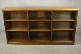 A late 19th century oak open bookcase, the shelves and dividers with chamfered edges, on a plinth