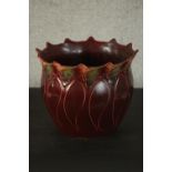 A Blakeney Pottery Art Nouveau burgundy jardiniere, L/S Fleur pattern, with a burgundy glaze,
