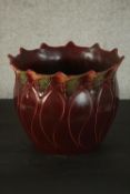 A Blakeney Pottery Art Nouveau burgundy jardiniere, L/S Fleur pattern, with a burgundy glaze,