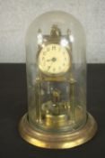 A brass anniversary clock, 20th century, with Arabic numerals to the enamelled dial, under a plastic