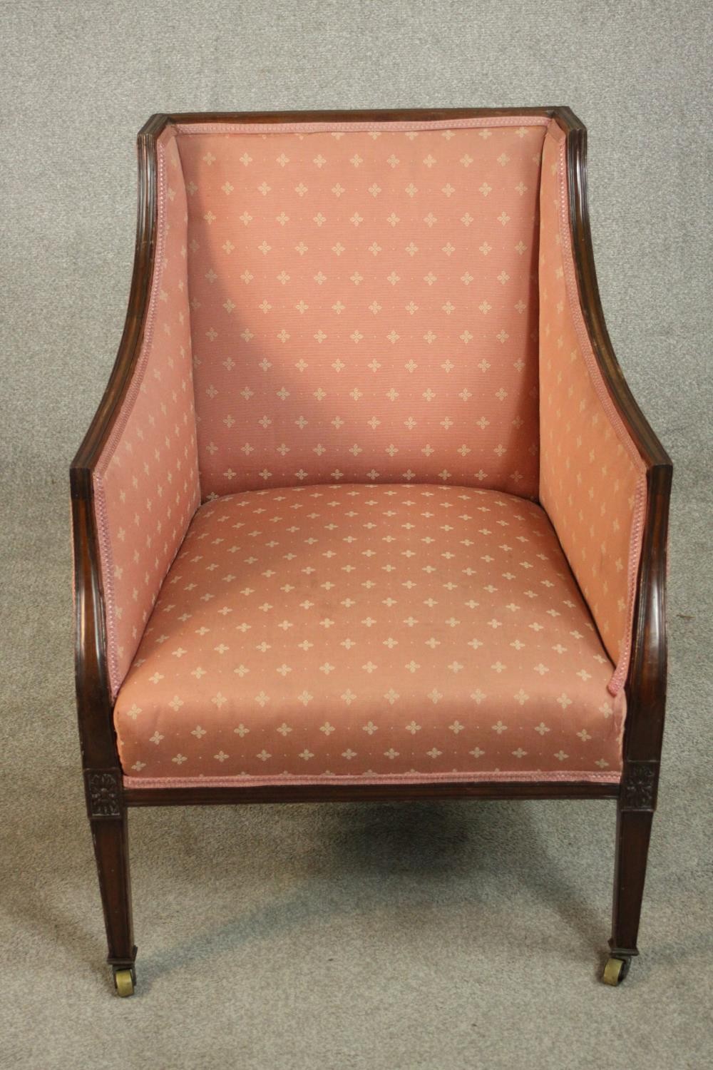An Edwardian Adam style mahogany armchair upholstered in pink fabric, on square section tapering