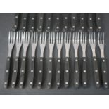 A Rostfrei Inox twelve person part black handled steak set with stainless steel blades and tines. (