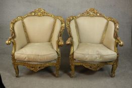 A pair of Louis XV style carved giltwood armchairs, 20th century, upholstered in beige fabric,