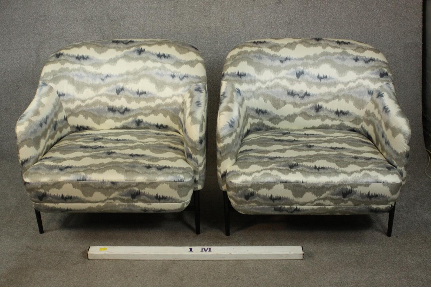 A pair of retro styled armchairs, with patterned upholstery in hues of grey, on a black powder - Image 2 of 13