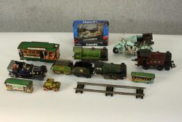 A collection of ten vintage tin plate and die cast toy locomotives, including trains, cars,