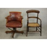 An early 20th century swivel desk chair uoholstered in burgundy leather, on a four point base,