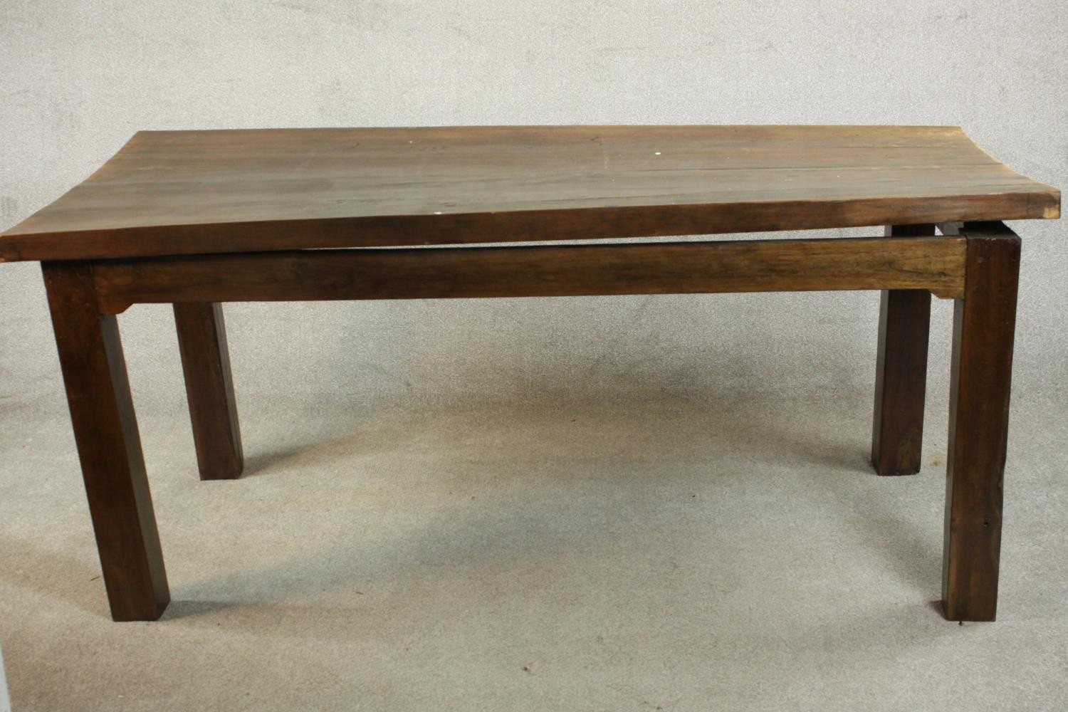A contemporary hardwood dining table, with a rectangular plank top on square section legs. (badly