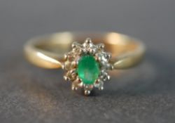 A 9 carat gold vintage emerald and diamond cluster ring, set to the centre with an oval mixed cut