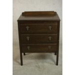 An early 20th century oak chest, with a gallery back over three long drawers, on square section