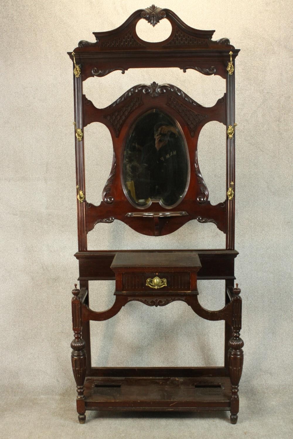 A late Victorian Chippendale style walnut hall stand, the scrolling pediment with blind fretwork
