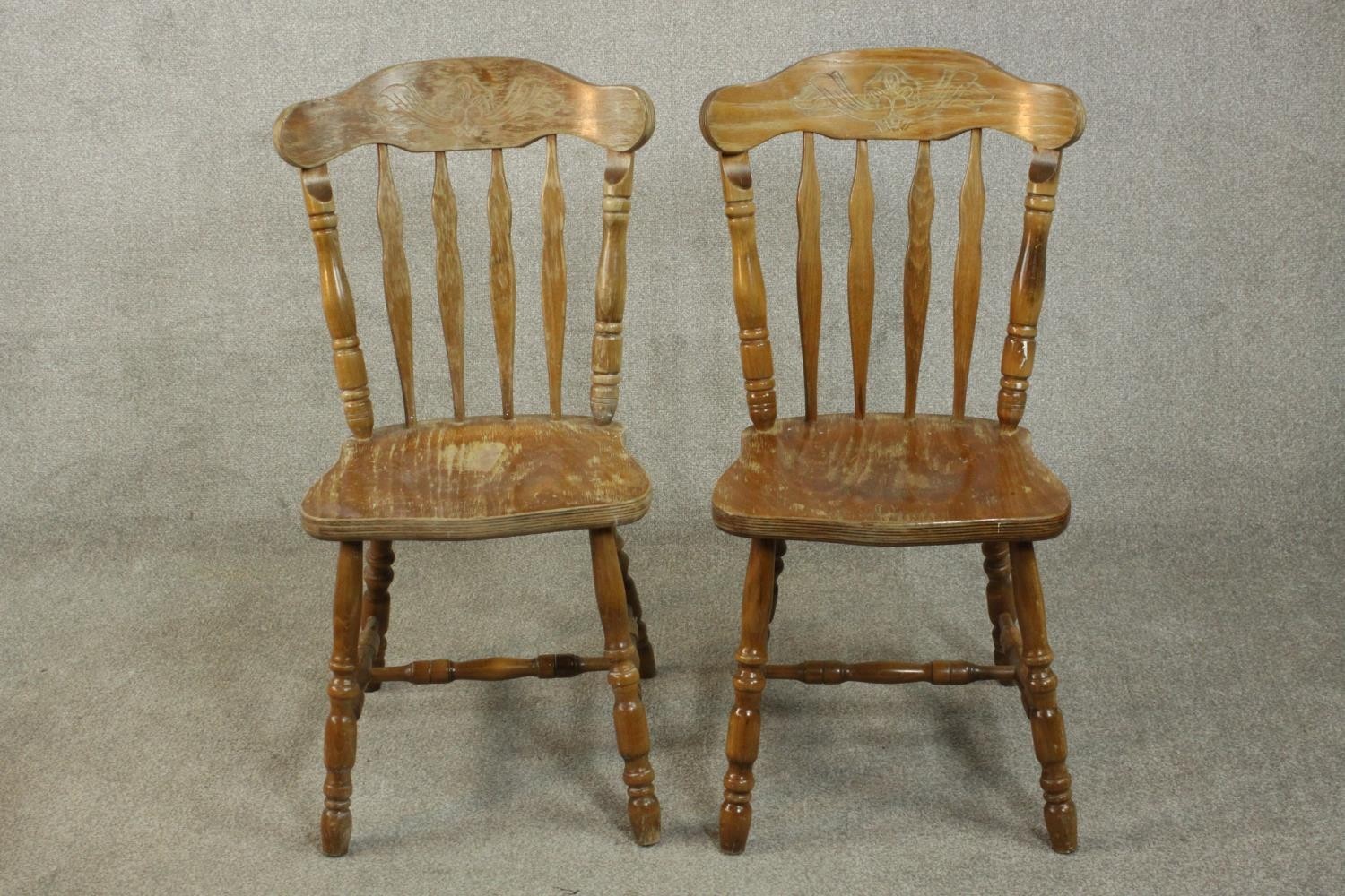 A pair of continental Windsor style plywood and pine kitchen chairs, with carved bar backs, shaped
