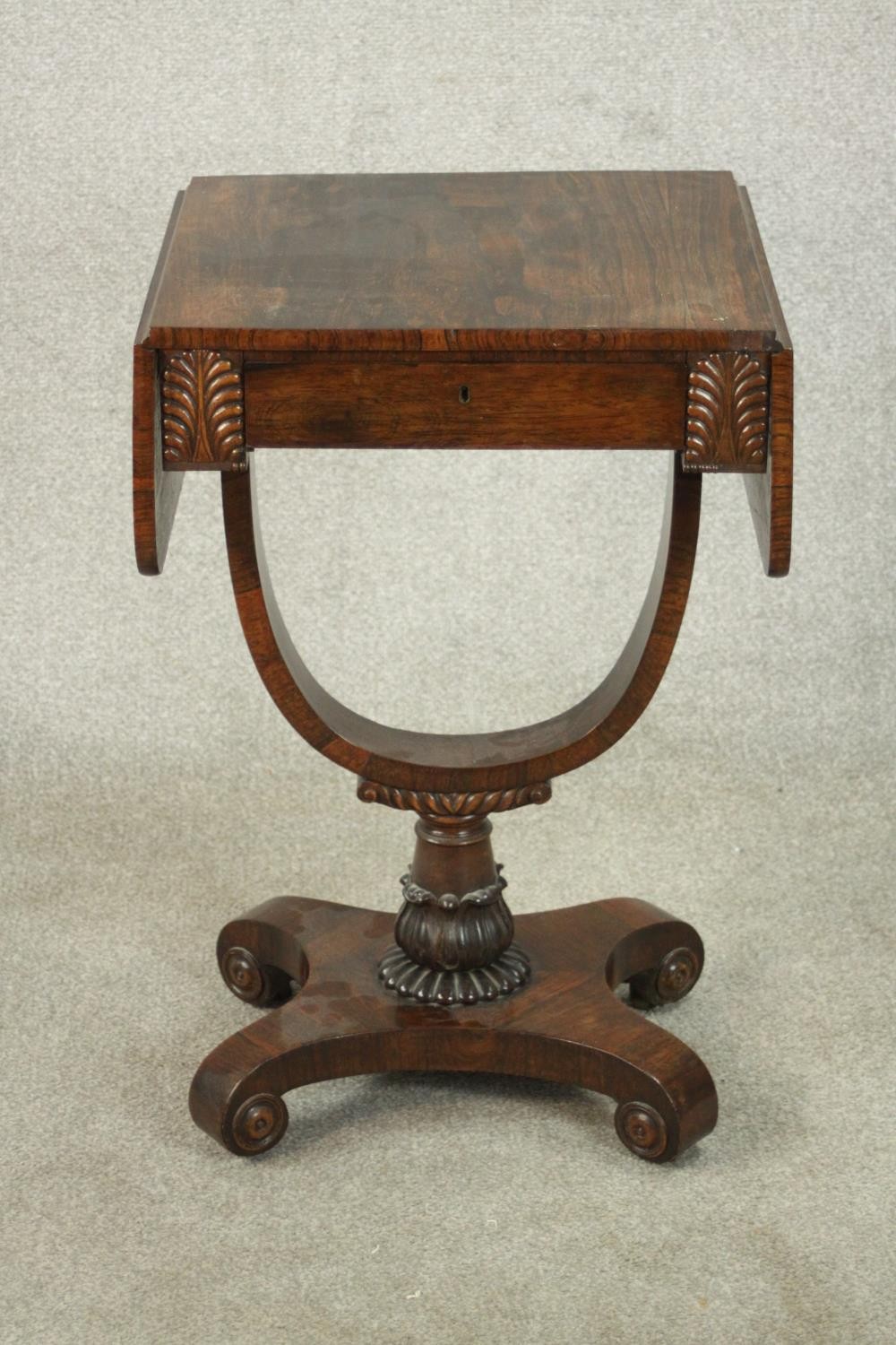 A William IV rosewood drop leaf work table, with a single drawer flanked by applied palm leaves,