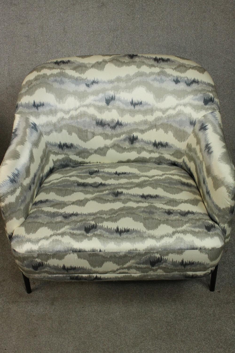 A pair of retro styled armchairs, with patterned upholstery in hues of grey, on a black powder - Image 3 of 13