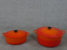 Two orange Le Creuset lidded casserole dishes. H.18 Diam.35cm (largest)