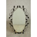 An oval wrought iron framed mirror, with a scrolling leaf frame along with a circa 1900 walnut