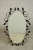 An oval wrought iron framed mirror, with a scrolling leaf frame along with a circa 1900 walnut