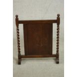 An early 20th century fire screen, the central panel with a lozenge design, flanked by barley