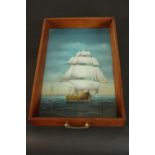 A reverse painted glass tray depicting a sailing ship, the tray with pine sides and swing brass