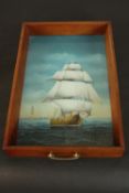 A reverse painted glass tray depicting a sailing ship, the tray with pine sides and swing brass