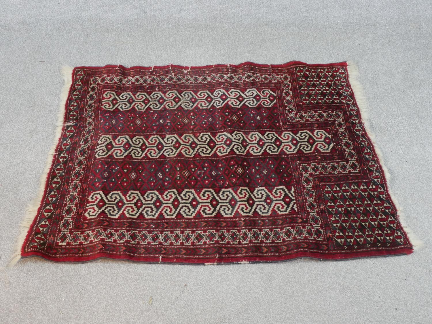A red ground handmade Persian Turkman rug. L.115 W.100cm