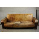 A Heal's style Art Deco brown leather sofa with integral book shelves to the sides and rear. H.95