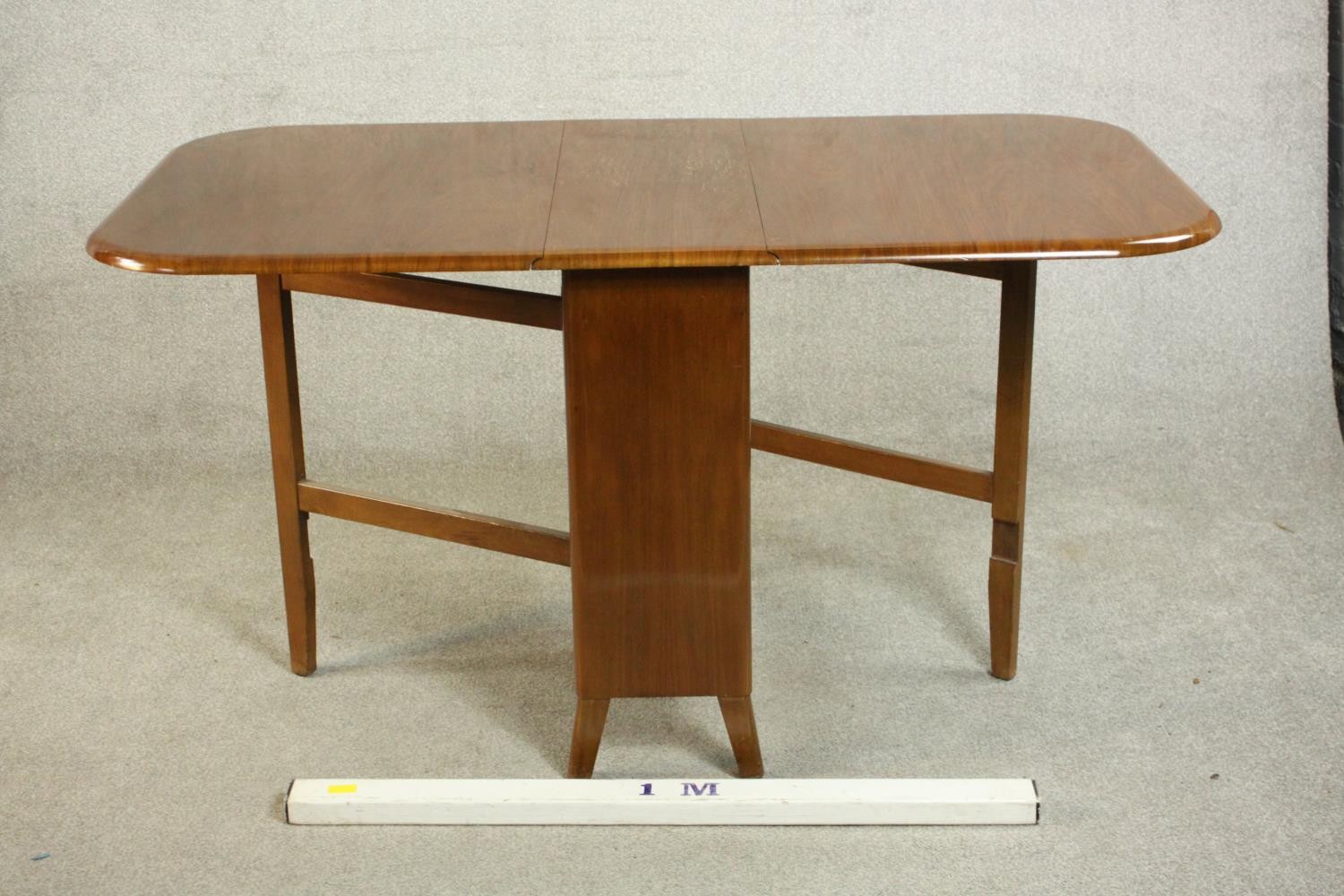 A mid 20th century walnut drop leaf dining table, the two leaves with rounded corners on a base with - Image 2 of 9