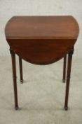 A mahogany drop leaf Pembroke style table, the oval top with a crossbanded edge, on turned legs. H.