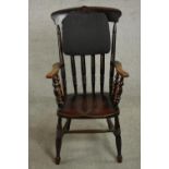 An ebonised Victorian bar back Windsor armchair, with turned spindles supporting the arms, on turned
