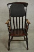 An ebonised Victorian bar back Windsor armchair, with turned spindles supporting the arms, on turned