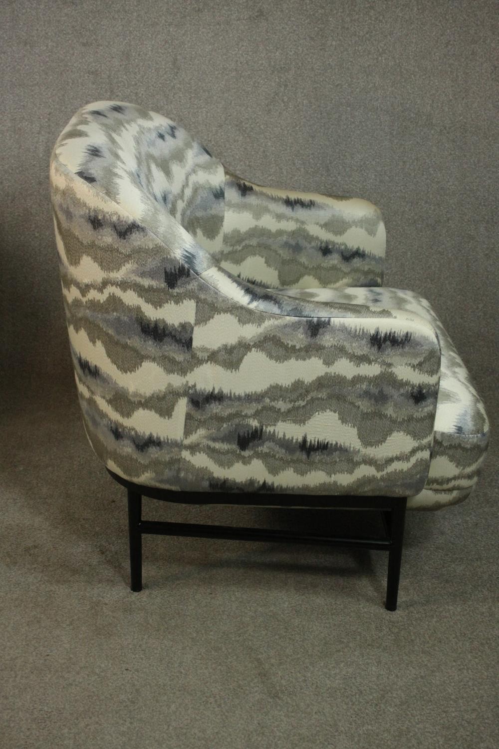 A pair of retro styled armchairs, with patterned upholstery in hues of grey, on a black powder - Image 6 of 13
