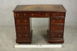 A small C.1900 mahogany pedestal desk, with a tooled green leather writing insert over an