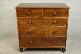 A 19th century flame mahogany chest of two short over three long drawers with knob handles, on