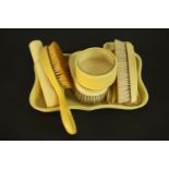 An Art Deco ivory Bakelite gentleman's dressing table set, including pin tray, clothes brushes,