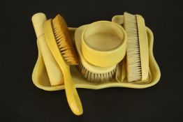 An Art Deco ivory Bakelite gentleman's dressing table set, including pin tray, clothes brushes,